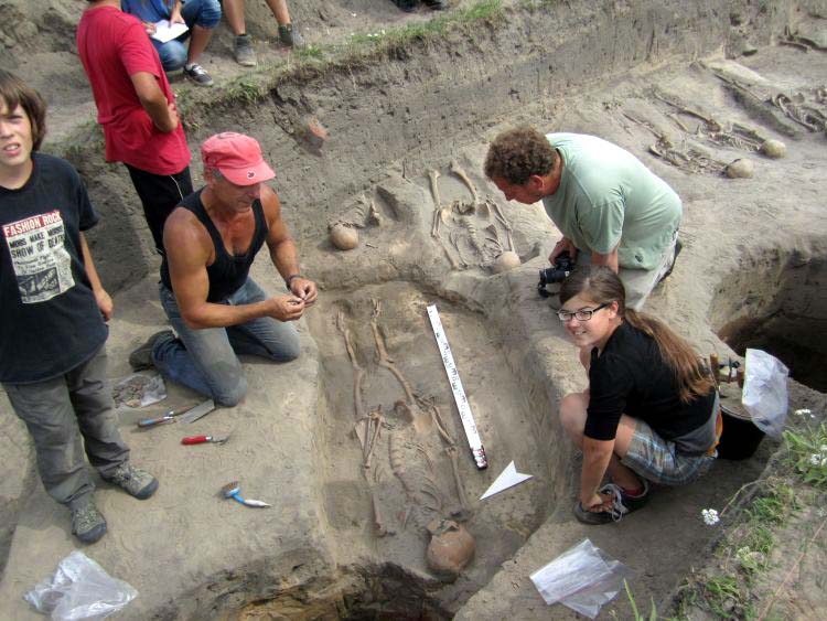 PD Dr. Biermann und Jürgen Theil, der gerade einen pommerschen Denar in den Händen hält, den er bei der Freilegung eines Grabes als Grabbeigabe fand.
